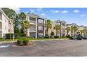 Exterior view of a multi-unit condo complex showcasing well-manicured landscaping and accessible parking spaces at 1298 River Oaks Dr. # 5-I, Myrtle Beach, SC 29579