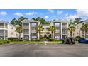 Charming condo complex showcases well-maintained landscaping, palm trees, and convenient parking spaces for residents at 1298 River Oaks Dr. # 5-I, Myrtle Beach, SC 29579