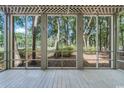 Covered porch with views of lush trees and greenery at 159-1 Weehawka Way # 159-1, Pawleys Island, SC 29585
