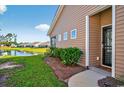 Charming backyard with a view of a pond, manicured lawn, and well-maintained landscaping at 1631 Hepburn Dr., Little River, SC 29566