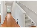 Hallway with hardwood floors leading to a carpeted staircase and living area at 314 Kiskadee Loop # 8-C, Conway, SC 29526