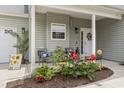 Inviting front porch decorated with chairs, colorful plants and a welcoming wreath on the front door at 3468 Trailside Dr., Little River, SC 29566