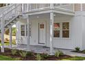 Close up of home's exterior featuring a welcoming entrance, well-maintained siding, and new landscaping at 409 2Nd Ave. S, Myrtle Beach, SC 29577