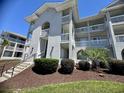 Condo exterior with balconies, stairs, and landscaping at 4430 Eastport Blvd. # L-11, Little River, SC 29566