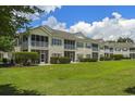 Backyard view of condos with screened porches and a large grassy area at 4430-G Montrose Ln. # G, Myrtle Beach, SC 29579