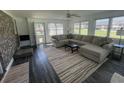 Bright and airy living room featuring a large sectional sofa, wood-look flooring, and ample natural light at 4637 Dogwood St., Loris, SC 29569