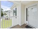 View of a condo balcony with a white railing, exterior door and green shutter at 4924 Pond Shoals Ct. # 201, Myrtle Beach, SC 29579