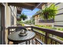 Balcony view with a table and hanging plants of a condo building on a sunny day at 6813 Porcher Dr. # 25, Myrtle Beach, SC 29572