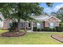 Charming brick home with blue shutters, manicured landscaping, and a welcoming front entrance at 7007 Blade Beak Ln., Myrtle Beach, SC 29588