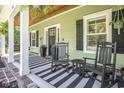 Welcoming front porch with rocking chairs and stylish striped rug at 769 Country Club Dr., Pawleys Island, SC 29585