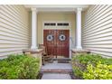 Charming front porch with double doors, a rocking chair, and stone accents offering a warm welcome at 86 Wickham Ct., Pawleys Island, SC 29585