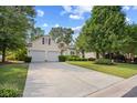 Well-maintained home featuring a long driveway, verdant lawn, mature trees, and a two-car garage at 86 Wickham Ct., Pawleys Island, SC 29585
