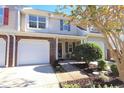 Lovely townhouse with a one-car garage, brick accents, and well-maintained landscaping enhancing its curb appeal at 107 Pawleys Place Dr. # 107, Pawleys Island, SC 29585