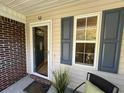 Inviting front porch with a horseshoe, decorative brick, and charming gray shutters beside a window at 107 Pawleys Place Dr. # 107, Pawleys Island, SC 29585