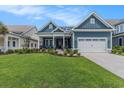 Charming blue two-story home with a well-manicured lawn and an attached two-car garage at 1131 East Isle Of Palms, Myrtle Beach, SC 29579