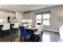 Well-lit dining area with hardwood floors and views of green fields out the window at 1416 Whistling Straits Way, Sunset Beach, NC 28468