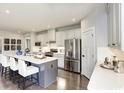 Modern kitchen featuring white cabinets, stainless steel appliances, and an island with seating at 1416 Whistling Straits Way, Sunset Beach, NC 28468
