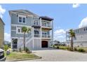 A beautiful light blue home with a spacious driveway, and a multi-level porch at 1512 Riverside Dr., Sunset Beach, NC 28468