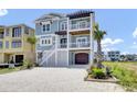 Charming coastal home with a white staircase, a garage, and lush tropical landscaping at 1512 Riverside Dr., Sunset Beach, NC 28468