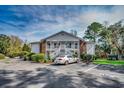 Inviting two-story condo featuring white siding and a charming exterior staircase and landscaping at 251 Egret Run Ln. # 1122, Pawleys Island, SC 29585