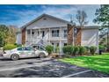 Inviting two-story condo featuring white siding and a charming exterior staircase and landscaping at 251 Egret Run Ln. # 1122, Pawleys Island, SC 29585