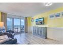 Cozy living room with ocean view balcony, TV, and side table and ocean-themed decor at 2801 S Ocean Blvd. # 538, North Myrtle Beach, SC 29582