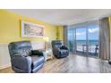 Bright living room featuring cozy chairs, stylish lamps, and a sliding glass door to the balcony with ocean views at 2801 S Ocean Blvd. # 538, North Myrtle Beach, SC 29582