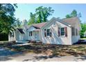 Classic white brick home featuring multiple entryways, chimney, and traditional design elements at 401 S Nichols St., Nichols, SC 29581