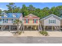 Three cute coastal homes, elevated construction, lined up on a picturesque street, perfect for beach living at 4319 Grande Harbour Blvd., Little River, SC 29566
