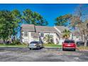 Exterior of a two-story condo featuring a parking lot in the foreground and mature trees in the background at 4486 Little River Inn Ln. # 2106, Little River, SC 29566