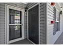 Condo entrance with a storm door and a solid door with gray siding, plus a mail box at 4853 Meadowsweet Dr. # 1805, Myrtle Beach, SC 29579