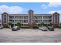 Condo building exterior with balconies and parking in front showing blue sky with white clouds at 4853 Meadowsweet Dr. # 1805, Myrtle Beach, SC 29579