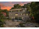 Two-story home with grey siding, green shutters, two-car garage, and landscaped front yard at dusk at 515 River Rd., Conway, SC 29526