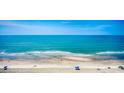 Panoramic beach view with ocean waves rolling onto the shore with people enjoying the sun at 5310 N Ocean Blvd. # 10B, North Myrtle Beach, SC 29582