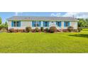Charming single story home featuring bright blue shutters, a manicured lawn, and an inviting front porch at 5589 Highway 668, Conway, SC 29526