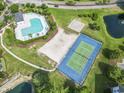Aerial view showcasing community amenities: swimming pool, tennis court, volleyball court, and pond at 5801 Oyster Catcher Dr. # 332, North Myrtle Beach, SC 29582