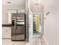 Inviting entryway featuring tiled floors, stainless steel refrigerator, and an open doorway leading to carpeted stairs at 601 Hillside Dr. N # 2135, North Myrtle Beach, SC 29582