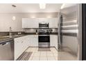 Well-equipped kitchen with stainless steel appliances, granite countertops, white cabinets, and tiled flooring at 601 Hillside Dr. N # 2135, North Myrtle Beach, SC 29582