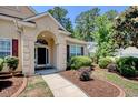 Inviting front entrance with an arched doorway and lush landscaping, adding to the home's curb appeal at 6705 Oakmere Ct., Murrells Inlet, SC 29576