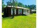 Charming single-story brick home with a well-maintained lawn and mature trees in a suburban neighborhood at 704 W Alder St., Andrews, SC 29510