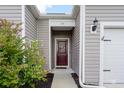 Close-up of the front door with burgundy paint, a decorative wreath, and a small front garden at 715 Tattlesbury Dr., Conway, SC 29526