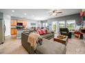 Open concept living room with cozy gray sofa, modern ceiling fan, and plenty of natural light at 715 Tattlesbury Dr., Conway, SC 29526