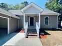 Charming single story home exterior with covered porch, painted steps, and lush landscaping at 1000 Weldon Ln., Conway, SC 29526