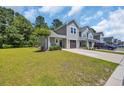Townhome featuring a lush green lawn and a concrete driveway leading to the garage at 132 Machrie Loop # A, Myrtle Beach, SC 29588