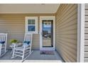 Inviting front porch with rocking chairs and a decorated glass front door at 132 Machrie Loop # A, Myrtle Beach, SC 29588