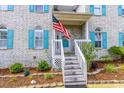 Charming entrance with staircase, American flag, and neatly landscaped bushes at 1437 Baldwin Ct. # 1437, Little River, SC 29566