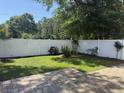 The backyard has a white fence and is beautifully landscaped with green grass and trees at 152 Rose Water Loop, Myrtle Beach, SC 29588