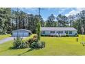 Traditional home with a detached garage offers ample space and curb appeal with a well-manicured lawn at 203 Warbler St., Georgetown, SC 29440