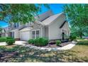 Features green bushes, fresh paint, and an attached two-car garage at 205 Threshing Way # 1052, Myrtle Beach, SC 29579