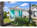 Charming turquoise house with a cozy front porch, garden, and white picket fence at 230 Addison Cottage Way, Murrells Inlet, SC 29576